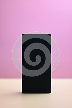 black battery for smartphone on orange and pink background