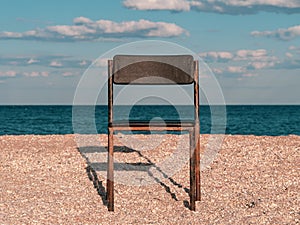 Black beach chair on empty sand beach with blue sea water background Minimalism style autumn travel relaxation No people
