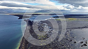 Black Beach in Iceland Aerial View, Green Grass Grow From Black Sand, Unearthly Landscape