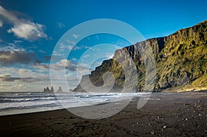 Black Beach and Sea-stacks in Vik Iceland with mountains waves a