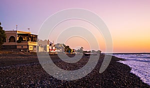 Black beach sunrise view Kamari village Santorini Greece