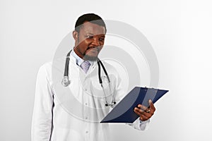 Black bearded doctor man in white robe with stethoscope holds medical chart on clipboard