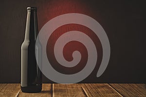 black beer bottle with red light background/ black beer bottle with red light background. Selective focus and copyspace