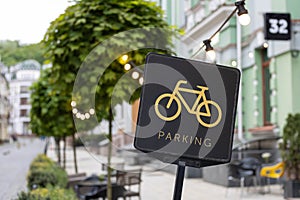 A black bicycle sign with a picture of yellow bike and text parking