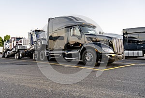 Black big rig powerful semi truck transporting coupled another semi tractors