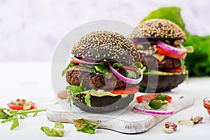 Black big sandwich - black hamburger with juicy beef burger, cheese, tomato, and red onion