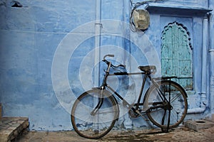 A black bike against a blue wall