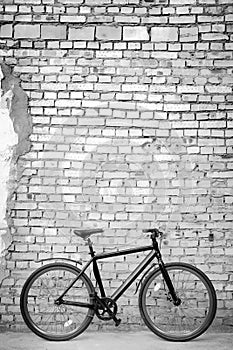 Black bike against brick wall