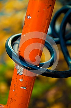 A black bike lock on an orange bike
