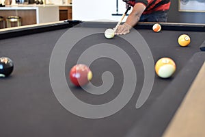 Black billiard table, Playing snooker pool 8ball - Close-up shot of a man playing billiard