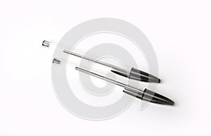 Black biro pens on a white background