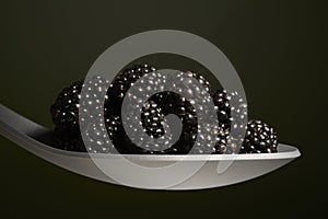 Black blackberries on spoon