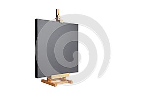 Black blank cotton canvas stretched on subframe and a wooden table easel, isolated on white