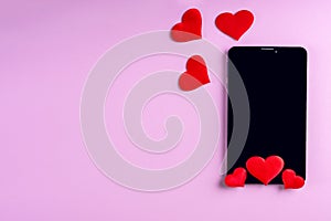 Black blank phone screen with red heart shape on pink background, copy space, minimalism, flat lay