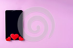 Black blank phone screen with red heart shape on pink background, copy space, minimalism, flat lay