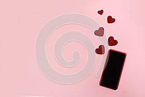Black blank phone screen with red hearts on pink background, copy space, minimalism, flat lay. Valentine day concept. Concept to