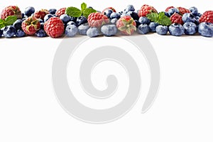 Black-blue and red berries. Ripe raspberries, blueberries with mint on white background. Berries at border of image with copy spac