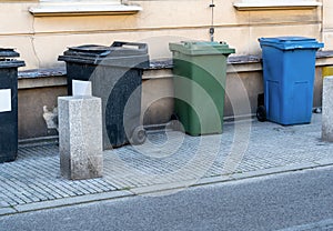 Black, blue, yellow, green garbage containers in city.  Separate waste, preserve the environment concept. Segregate waste,