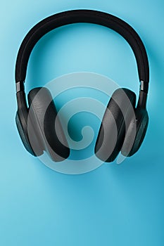 Black bluetooth headphones on a blue background top view. In-Ear Headphones for DJs