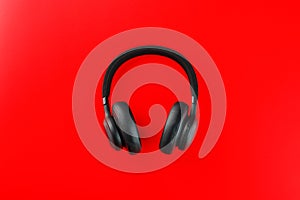 Black bluetooth headphones on a red background top view. In-Ear Headphones for DJs