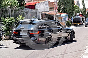 Black BMW M3 Competition Touring xDrive G81 on the road