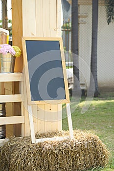 Black board stand on straw decorate with flowers vase