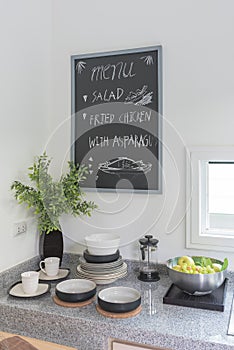 Black board on white wall in modern kitchen room with utensil