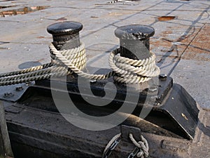 Black bollards on the harbor wall for attachment to the ship