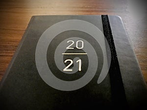 A black book of 2021 on a wooden background.