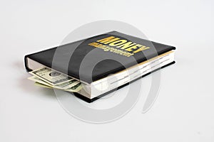 Black book with money and the inscription money management on white background