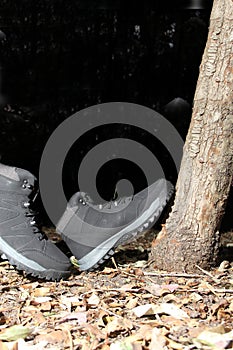 Black boots in the dark forest between trees ready for hiking in the mountains to explore at night