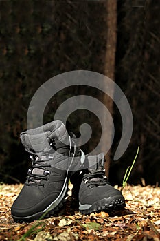 Black boots in the dark forest between trees ready for hiking in the mountains to explore at night