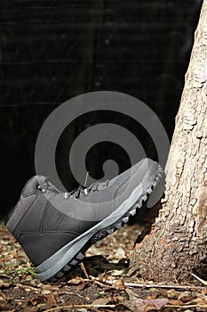 Black boots in the dark forest between trees ready for hiking in the mountains to explore at night