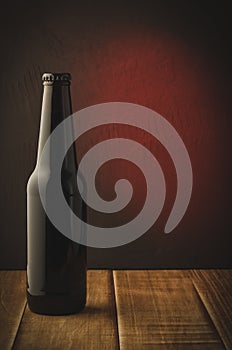 black bottle of beer on a red background of a wooden shelf/black bottle of beer on a red background of a wooden shelf. Selective