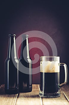 Black bottle and glass beer on a dark background with red light black bottle and glass beer on a dark background with red light.