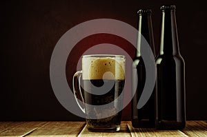 black bottle and glass beer on a red background of a wooden shelf/black bottle and glass beer on a red background of a wooden