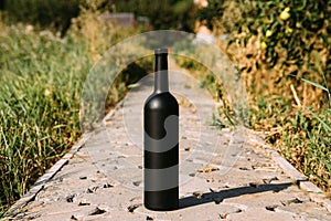 Black bottle on the road from the tiles, the village, rural alcoholism, drunkenness. alcoholic illness. wine natural drink. wine