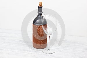 Black bottle of wine and wneglass on the wooden background