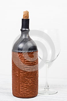 Black bottle of wine and wneglass on the wooden background