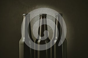 black bottles of beer on a dark background with light/black bottles of beer on a dark background with light. Selective focus