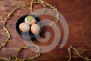 Black bowl with brown colored Easter eggs on rustic background. Spring, Easter concept. Top view, copy space