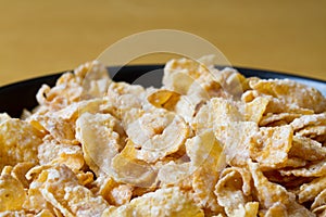 Black bowl with frosted cereal flakes