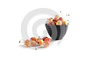 Black bowl of white cherry isolated on white background