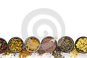 Black bowls of dry medicinal herbs on white background. Top view, flat lay. Alternative medicine.