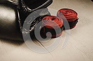 Black boxing gloves and red bandage/sport concept with black boxing gloves and red bandage. Selective focus