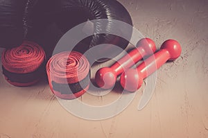 black boxing gloves and red dumbbells and bandage/ sport and boxing concept with black boxing gloves and red dumbbells and bandage