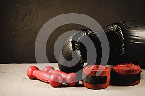black boxing gloves and red dumbbells and bandage/sport concept with black boxing gloves and red dumbbells and bandage