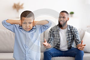 Black Boy Covering Ears While Angry Father Shouting At Home