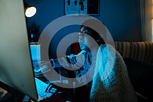 Black boy working with computer while sitting at table at home