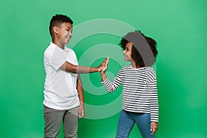 Black boy and girl laughing while giving high fives